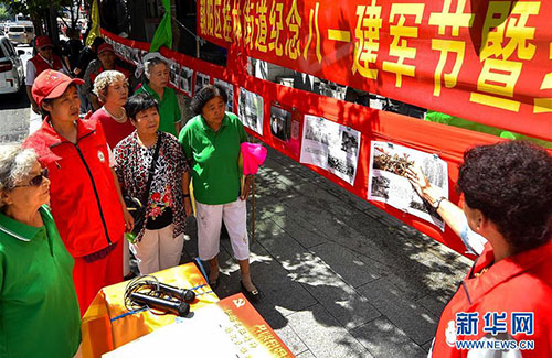 长春市民自制展板纪念八一建军节及红军长征胜利80周年