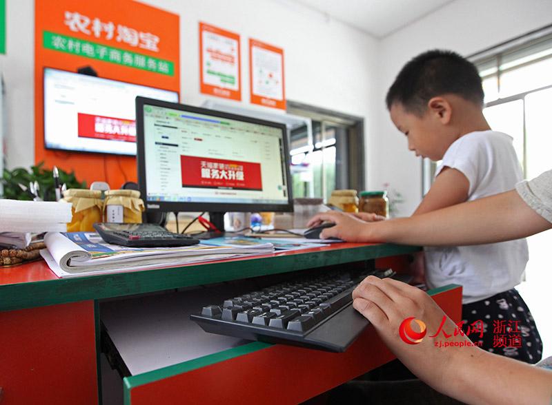 一个村庄中心点、一条专用网线、一台电脑、一个超大屏幕、一帮经过培训的技术人员。章勇涛 摄