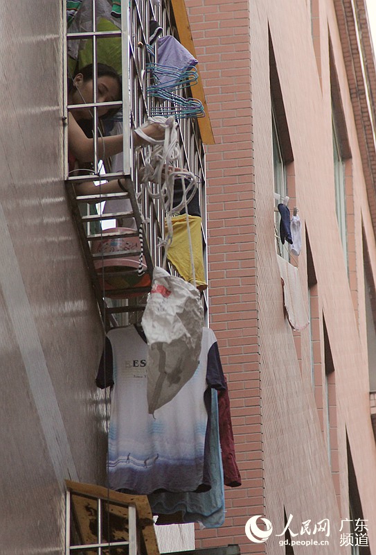 &ldquo;垂绳快递&rdquo;是里仁洞村的特色景象。快递员在巷子里高声呼喊收件人的姓名，然后，位于出租屋高层的阳台处缓缓垂下一个袋子，快递员熟练地把包裹装进去，袋子又被慢慢拉回屋内。钟哲 摄