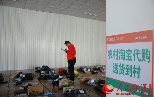 农村淘宝整合第三方物流构建了农村服务网络。图为快递员在县级服务中心分拣快递。这些快递几个小时内就可以送至农村。张梦琪 摄