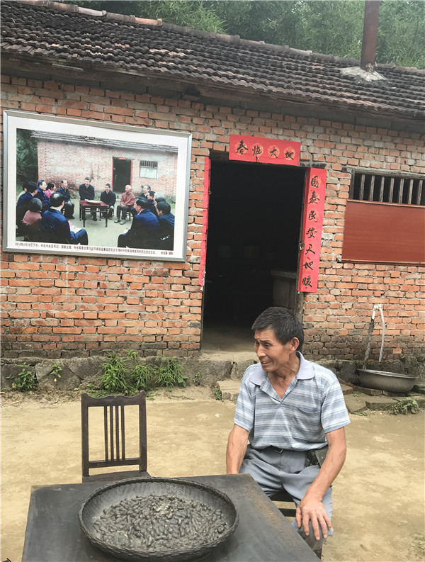 图为7月3日下午,大湾村村民陈泽申坐在两年前和习近平总书记合影的